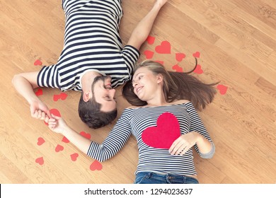 Happy valentines couple lying on the floor and looking at each other. Top view, toned. - Shutterstock ID 1294023637