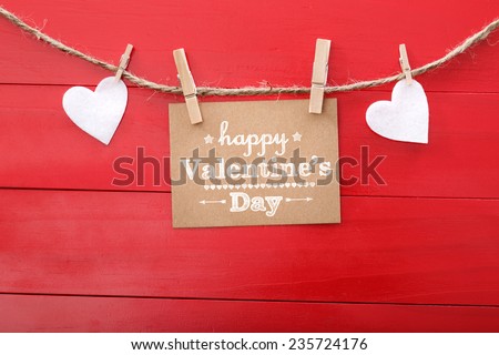 Happy Valentine's Day card with hearts and clothespins on red wood