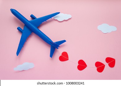 Happy Valentines day. Children's plane on a pink background with red heart, and garland in the shape of a heart