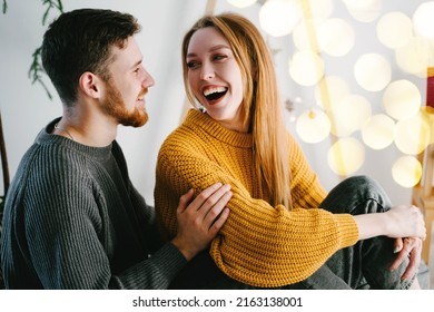 Happy Valentines Day. Yellow light bulbs in out of focus. Romantic couple of lovers against the background of a Christmas tree made of natural wood. Yellow bokeh. - Powered by Shutterstock