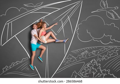 Happy Valentines Love Story Concept Of A Romantic Couple On Chalk Drawings Background. Couple On A Date Hang Gliding Over A Countryside, Female Pointing At The Flying Duck.