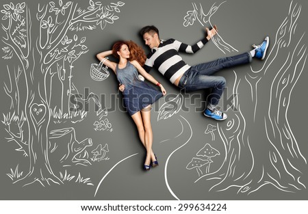 Happy valentines love story concept of a romantic couple walking in the wood and flirting against chalk drawings nature background.