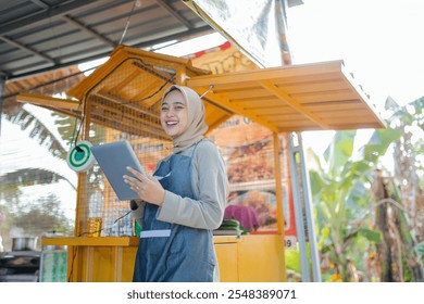 A happy vendor uses a sleek tablet at a vibrant food stall amidst the beauty of nature - Powered by Shutterstock