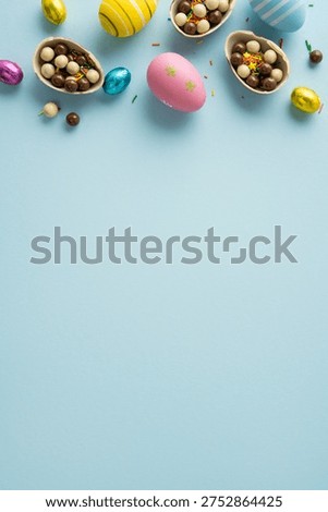 Happy vertical Easter greeting featuring pastel decorated eggs, cracked chocolate egg halves filled with candy, colorful sprinkles and foil eggs arranged on soft blue background for spring celebration