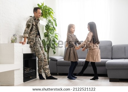 Happy veteran soldier comes back from the military and reunites with family. two children missed, home background