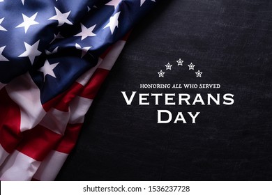 Happy Veterans Day. American flags with the text thank you veterans against a blackboard background. November 11.