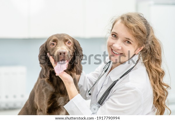 Happy\
veterinarian doctor hugs a dog at vet\
clinic