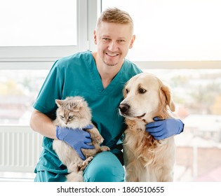 Happy Veterinarian Hugging Dog And Cat