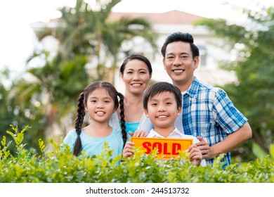 Happy Vietnamese Family Holding Sold Sign