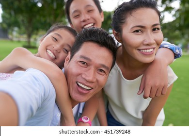 Happy Vietnamese family hugging when photographing together - Powered by Shutterstock