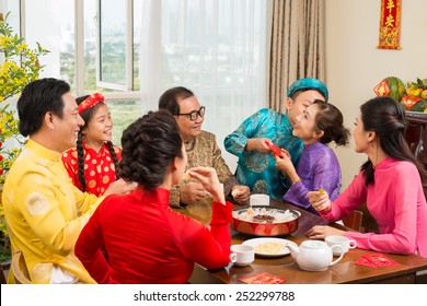 Happy Vietnamese family at the table celebrating Tet