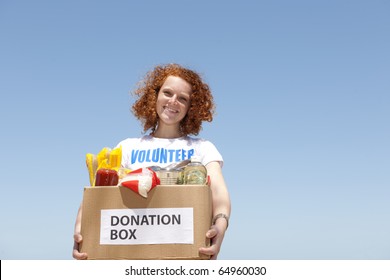 Happy Volunteer Carrying Food Donation Box