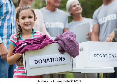 Happy volunteer family holding donation boxes on a sunny day