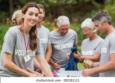 Happy volunteer looking at donation box on a sunny day - Shutterstock ID 282281111