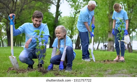 Happy Volunteers Family Planting Tree Saplings Outdoors, Enjoying Made Work