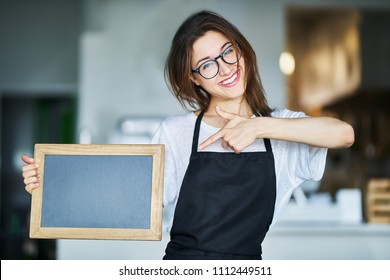 Happy Waitress Holding Blank Chalkboard Sign