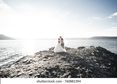 Happy wedding couple staying over beautiful landscape