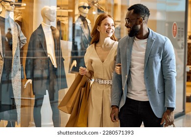 happy wife and husband spend their weekend at shopping mall. close up side view photo, cheerful couple strolling at shopping center , good mood, positive atmosphere between lovers