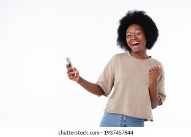 Happy As A Winner African Teenage Girl Using Smart Phone Isolated Over White Background