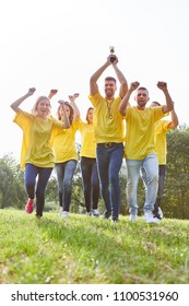 Happy Winner Team With Cup Cheers At A Team Building Event In Summer