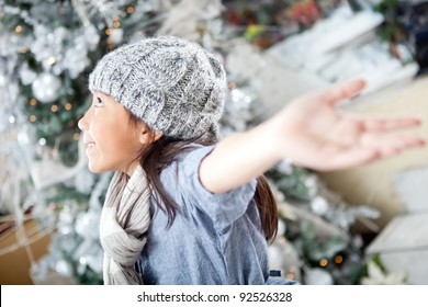Happy winter girl with arms open excited about Christmas Stock Photo