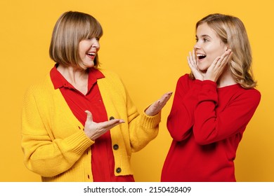 Happy Woman 50s Wear Red Shirt Have Fun With Teenager Girl 12-13 Years Old. Grandmother Granddaughter Talk Speak Spead Hands Hold Face Isolated On Plain Yellow Background. Family Lifestyle Concept.