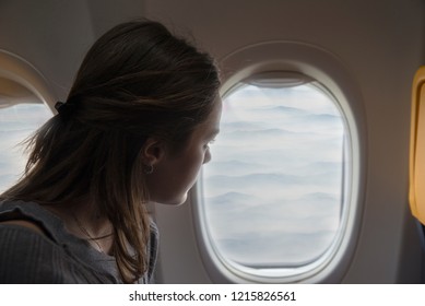 Happy Woman Admiring The View From The Window Of The Plane