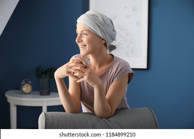Happy woman after chemotherapy drinking tea at home