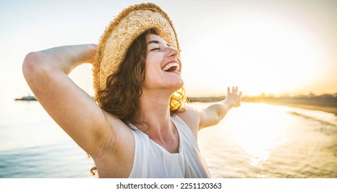 Happy woman with arms outstretched enjoying freedom at the beach - Joyful female having fun walking outside - Healthy lifestyle, happiness and mental health concept - Powered by Shutterstock