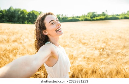 Happy woman with arms outstretched enjoying freedom in a wheat field - Joyful female breathing fresh air outside - Healthy life style, happiness and mental health concept - Powered by Shutterstock