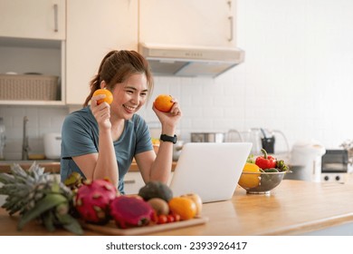 Happy woman asian in stylish tracksuit fresh smoothie shooting video with modern laptop in kitchen - Shutterstock ID 2393926417