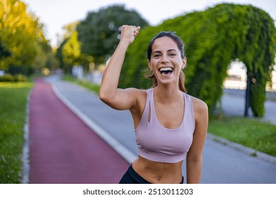 Happy woman in athletic wear celebrating success while exercising on a scenic outdoor path. The image captures feelings of accomplishment, joy, and motivation. - Powered by Shutterstock