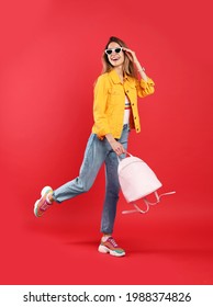 Happy Woman With Backpack On Red Background