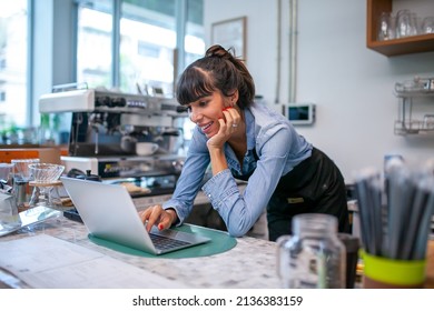 Happy Woman Barista Using Laptop For Take Order From Customer In Coffee Shop.