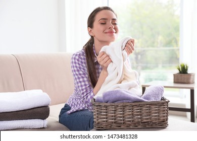 Happy Woman With Basket Of Laundry In Living Room