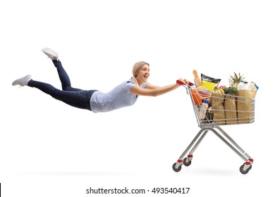 Happy Woman Being Pulled By A Shopping Cart Full Of Groceries Isolated On White Background