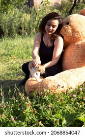 Happy Woman  With Big Teddy Bear  In  Garden