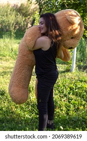 Happy Woman  With Big Teddy Bear  In  Garden