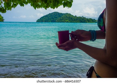 Happy Woman In Bikini Relaxing On Tree Branch In Sea Beach Her Hand Holding Cup Of Coffee, Andaman Sea, Mu Koh Surin National Park, Phangnga, Thailand