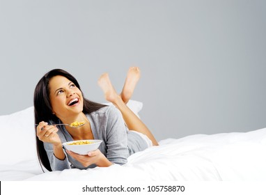 Happy Woman With Bowl Of Cornflakes Eating Breakfast In Bed. Healthy Start To The Day