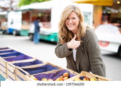 
Happy Woman Buys Apples At The Farmers Market