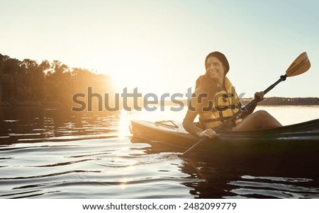 Happy woman, canoeing and paddling with sunset on ocean for travel, hobby or outdoor journey in water, lake or nature. Young female person, rowing boat and smile for sunshine adventure, kayak or sea