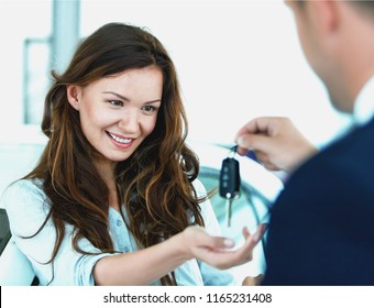 Happy woman with car dealer in auto