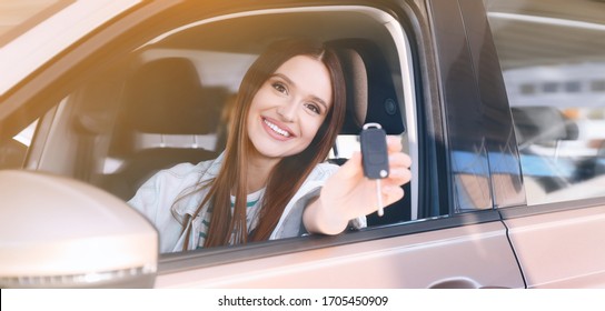 Happy woman with car key sitting in modern auto outdoors on sunny day. Banner design