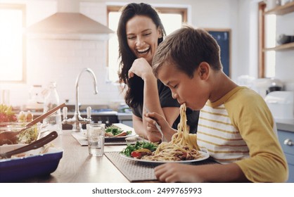 Happy woman, child and eating pasta with kitchen table, meal and food for dinner, holiday or vacation. Excited, people and hungry as family, mom and kid for nutrition, bonding and spaghetti in home - Powered by Shutterstock