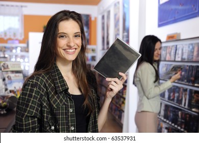 Happy Woman Choosing A Dvd At The Video Rental Store