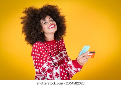 Happy Woman At Christmas Showing Plastic Credit Card While Holding Mobile Phone