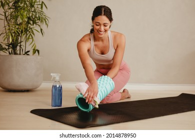 Happy  Woman Cleaning Exercise Roller And Mat With Disinfectant After Sports Training In Health Club. Gym Member Sanitizing And Cleaning Workout Equipment Before Exercising.