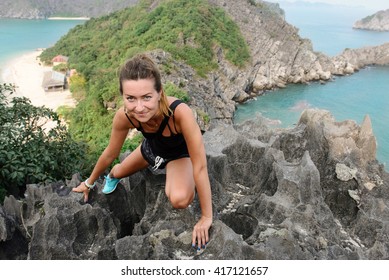 Happy woman climbing free on top of rocky mountains on Monkey Island, Ha Long Bay, Vietnam. Halong is popular tourist destination and UNESCO world heritage site - Powered by Shutterstock