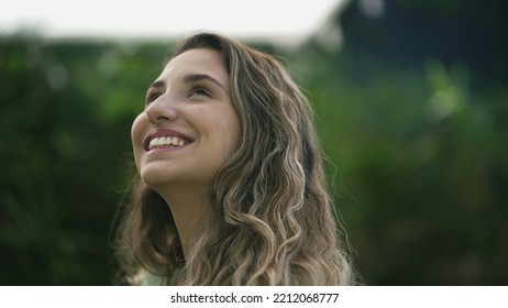 Happy Woman Closeup Face Looking Up At Sky Smiling. One Hopeful Hispanic 20s Adult Girl